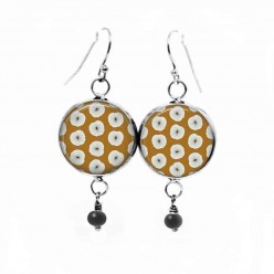 Dangle earrings with a white floral pattern on a mustard background