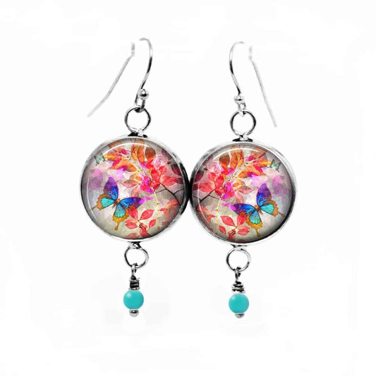 Boucles d'oreilles fantaisie pendantes avec le thème Summertime Papillon turquoise sur fond de feuilles rouges