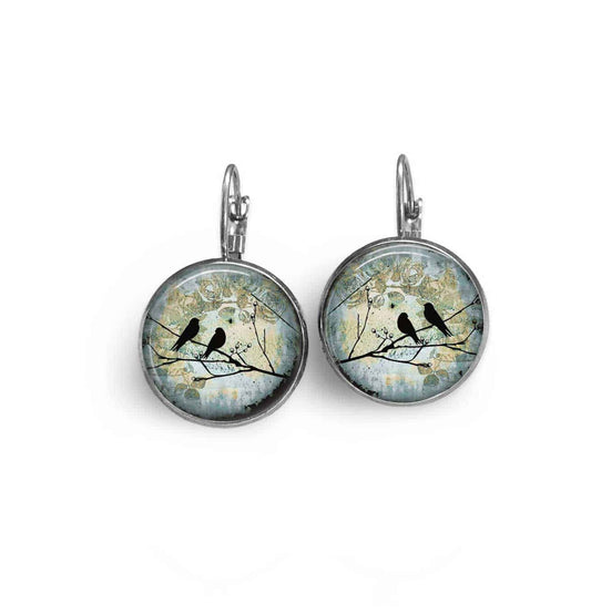 Boucles d'oreilles dormeuses thème oiseaux sur la branche sur fond bleu sarcelle