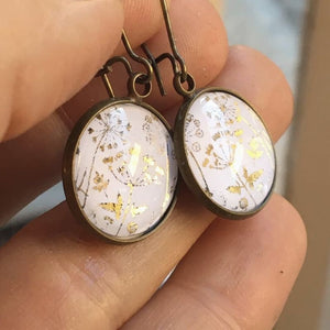 Boucles d'oreilles dorées sur le thème du champ de fleurs