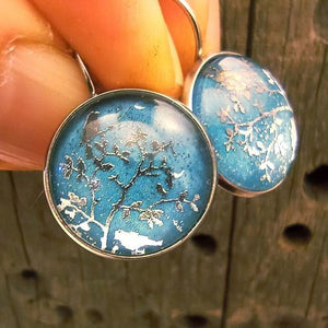 Blue bird earrings on the branch